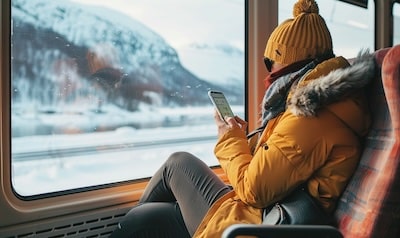 Person lærer polsk med språkapp på smarttelefon på et norsk pendlertog