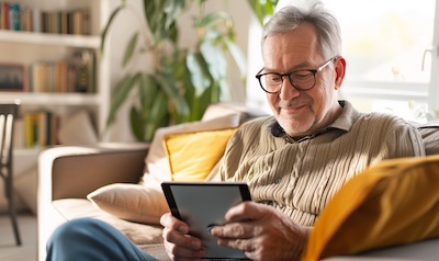 Older man learning Romanian on a tablet at home