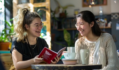 Two people practising spoken German together over coffee