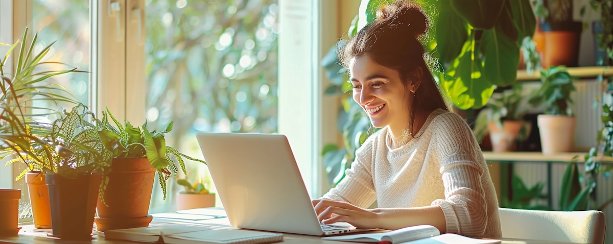 Young woman studying Persian on a laptop in a bright modern apartment
