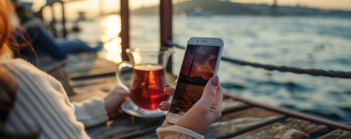 Best app to learn Turkish: a woman practicing Turkish on her smartphone on a Bosphorus ferry